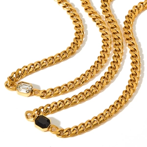 Detail of gold Cuban chain necklace with black and white rectangular gemstones