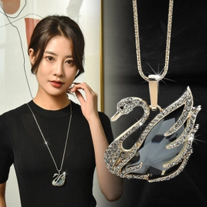 Detailed close-up of a silver swan pendant featuring a large dark grey gemstone