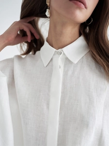 Gros plan du col de chemise en lin blanc et texture avec boucles d'oreilles perles