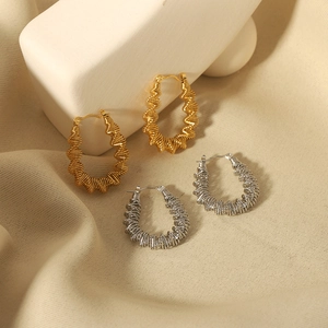 French vintage style hollowed out gold and silver twisted hoop earrings on stone props