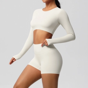 Detail of white yoga set featuring long sleeve crop top and high waist leggings