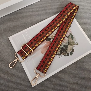 Macro shot of retro checkered colorful woven bag strap with golden metal hardware detail