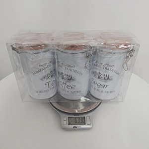 Three-piece white tinplate coffee sugar tea canister set on scale weighing 633g