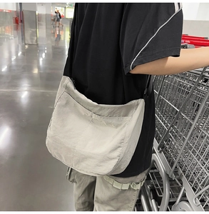 Detail of light grey nylon messenger bag with multi-layer zipper and large capacity