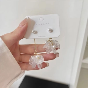 Detail of floral drop earrings featuring white pearls and translucent petals