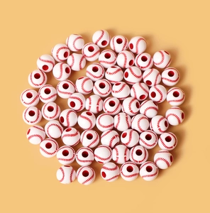 Detailed view of white acrylic baseball beads with red stitching on a yellow background