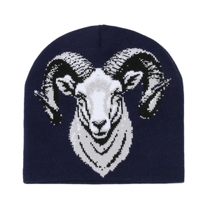 Close-up of navy blue knit beanie featuring detailed ram head jacquard pattern and texture