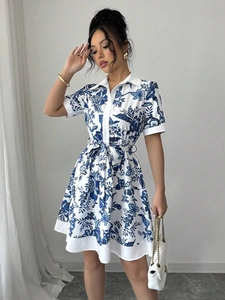 Detail of blue and white floral print shirt dress with waist tie and button-down front