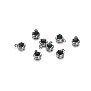 Détail de 8 pendentifs en acier argenté sertis de pierres de zircone rondes sombres