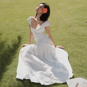 Détail de la robe blanche à col en V plissée en tissu texturé pour un look d'été chic