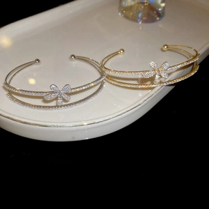 Detailed close-up of zircon flower double-layered open bracelets in gold and silver finish