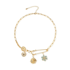 Collier trombone doré avec pendentifs pièce, étoile et fleur en diamant sur fond blanc pur