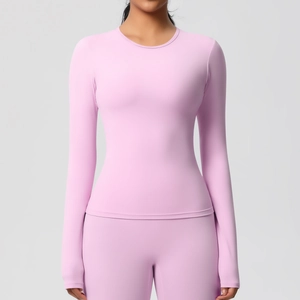 Détail des coutures plates et de la texture mate douce du haut de yoga rose à manches longues