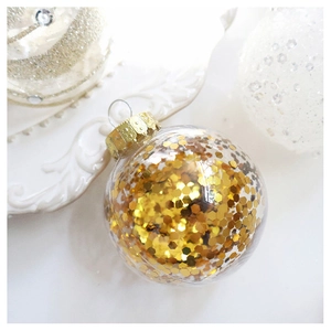 Detailed view of clear Christmas ornament ball filled with gold sequins and metal cap