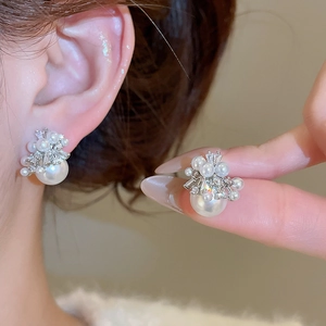 Close-up of elegant silver needle pearl earrings with brilliant zircon fireworks pattern