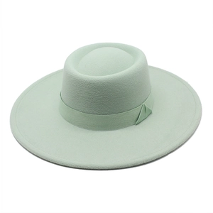 Close-up of mint green wool boater hat with matching ribbon band and flat brim
