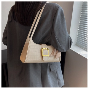 Detail of beige crocodile pattern baguette bag with silk scarf and gold D-ring buckle