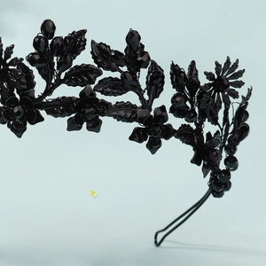 Macro detail of gothic black flower headband with intricate beadwork and metallic finish