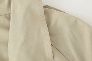 Detailed macro view of khaki twill fabric stitching and premium garment texture