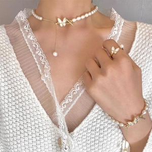 Detail of elegant butterfly pearl jewelry set with necklace bracelet and ring on model