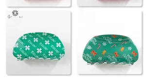Detail of green Christmas hair claws with Merry Christmas patterns and gingerbread motifs