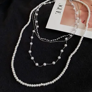 Elegant multi-layer vintage pearl and crystal beaded necklace on a black fabric backdrop
