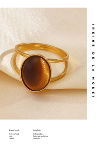 Macro shot of gold double-band ring featuring an oval brown cat-eye resin stone inlay