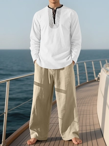Detail of white linen shirt and khaki pants worn on a yacht with ocean background