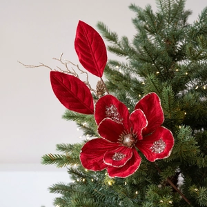 Artificial red velvet Christmas flower decoration with gold sequins on green tree branches