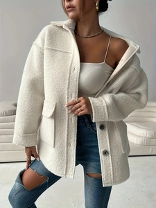 Detail of white faux fur jacket featuring large buttons and flap pockets for autumn style