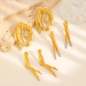 Détails de trois boucles d'oreilles créatives plaquées or avec incrustations de cristal