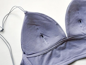 Detailed macro view of purple ribbed cotton bra interior showing removable pad pockets