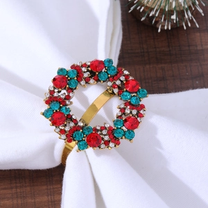 Macro detail of Christmas napkin ring with red and green zircons on gold alloy base