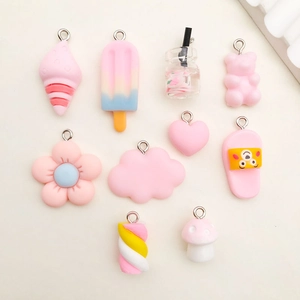 Detailed close-up of pink resin DIY pendants in various shapes with metal hooks