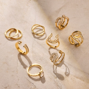 Macro detail of 8-piece gold-plated titanium ring set with white zircons and crystals