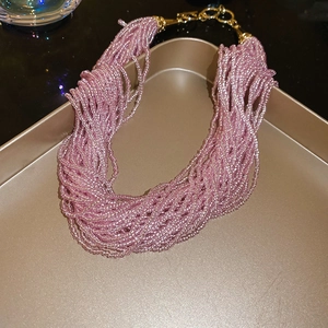 Detail of multilayer bead necklace with lavender crystals and gold-tone clasp on tray