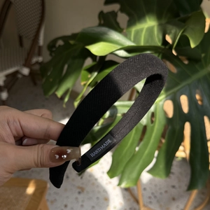 Détail d'un serre-tête noir rembourré fait main avec texture en tissu sergé