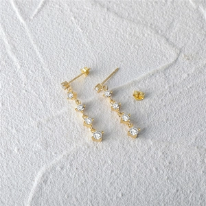 Macro detail of S925 sterling silver butterfly earrings with sparkling zircon tassels