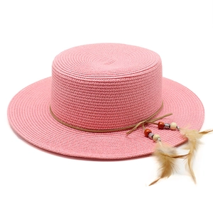 Pink flat top straw sun hat for women featuring beaded brown leather band and feathers
