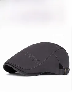 Detail of dark grey cotton newsboy cap featuring a bronze adjustable buckle and embroidery