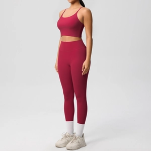 Side view of burgundy yoga set featuring thin strap bra and high-waist leggings on model