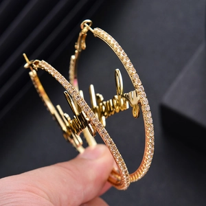Créoles dorées avec strass brillants et design personnalisé avec l'inscription Baby