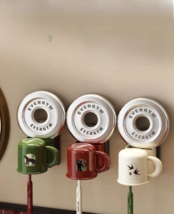 Wall-mounted magnetic cup holders with animal illustrations and hanging toothbrushes