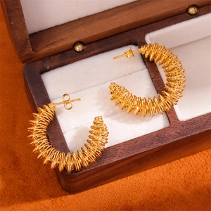 Golden C-shaped twisted spiral hoop earrings displayed in a premium wooden jewelry box
