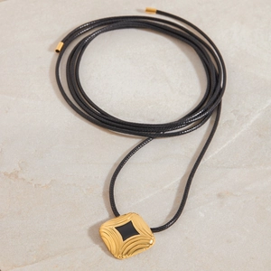 Elegant gold square pendant necklace with black enamel inlay on black braided cord