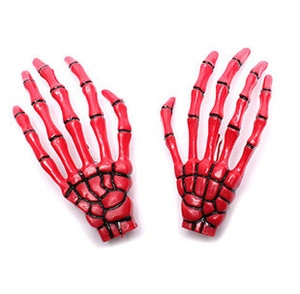 Detail of red skeletal hand hair clips showing anatomical bone joints and gothic design