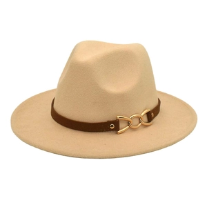 Detailed texture of beige wool fedora hat with brown leather band and gold metal chain