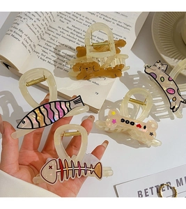 Detail of assorted cute cartoon puppy and fish hair claws in polished acetate material
