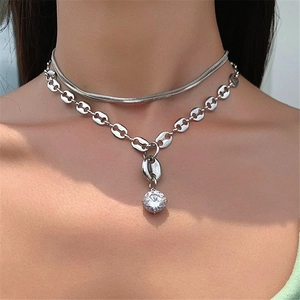 Silver layered necklace with snake chain, coffee bean links, and a zircon pendant detail