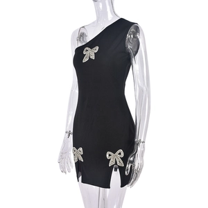 Detail of silver rhinestone bows on black single shoulder slim fit dress with side slit